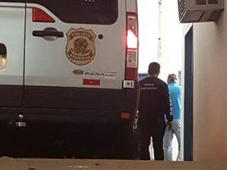Edson Giroto desembarcando e sendo escoltado por policial no Centro de Triagem (Foto: Mirian Machado)