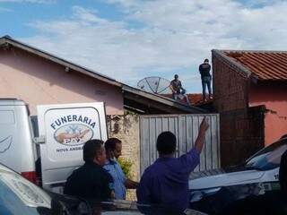 Policiais em cima do telhado da casa onde corpo de criança foi encontrado (Foto: Nova News) 