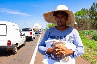 Vinicius aproveita parada de uma hora dos carros em obra para vender panos de prato. (Foto: Kisie Ainoã)