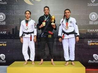 Ariadne Oliveira, ao centro, segura medalha e troféu conquistado em Abu Dhabi (Foto: Divulgação)