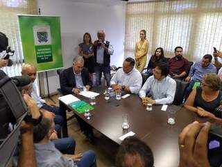 Na ponta da mesa, Reinaldo assina convênio com representantes de comércios (Foto: Leonardo Rocha)