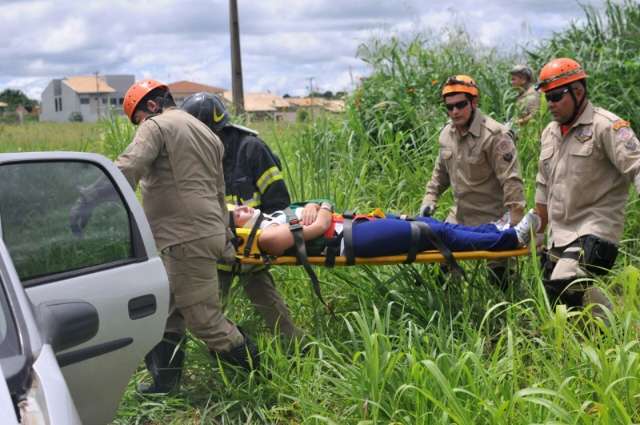 Veículos idênticos colidem em cruzamento e um vai parar em matagal