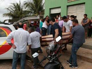 Familiares e amigos colocam caixão em carro de funerária para ser levado até o cemitério Santo Amaro, onde a vítima será sepultada. (Foto: Fernando Antunes) 