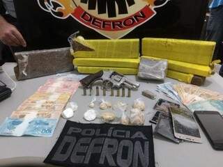 Drogas, dinheiros e arma apreendidos com os suspeitos. (Foto: DivulgaçãoDefron) 