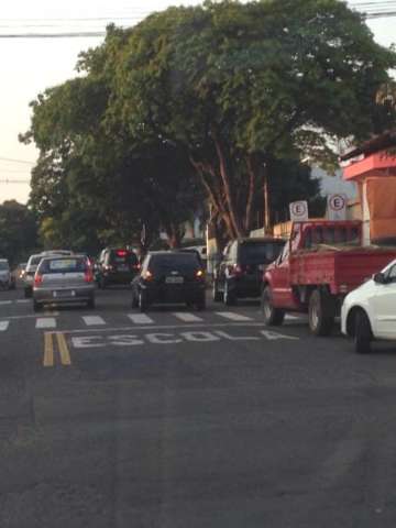 Leitor flagra ve&iacute;culos parados em fila dupla na frente escola