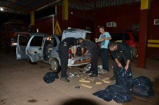 Policiais desmontam carro para retirar tabletes de maconha (Foto: Leo Veras)