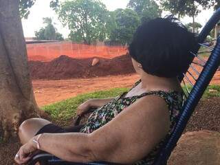 Dona Odete observando o buraco aberto na esquina de casa (Foto: Bruna Kaspary)