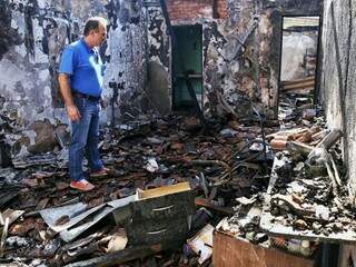 Um curioso observa a destruição no local; pouca coisa restou depois do incêndio nos salões comerciais (Foto: Fernando Antunes)