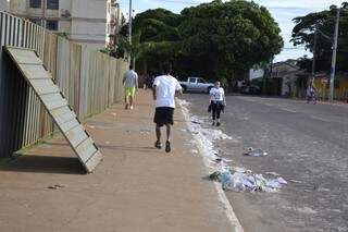 Tapumes impendem passagem e alguns moradores se arriscam caminhando na rua. (Foto: Pedro Peralta)