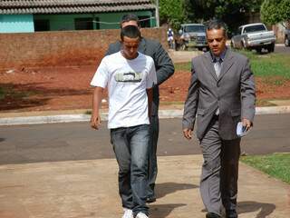 Flávio (camiseta branca e calça jeans) chegando á delegacia com advogado. (Foto: Pedro Peralta)