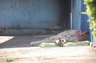 Alguns metros do acampamento, outro morador dorme na calçada do bairro (Foto: Pedro Peralta)