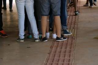 Em fila dupla, estudantes tem pés amarrados na caminhada pelos corredores. (Foto: Henrique Kawaminami)