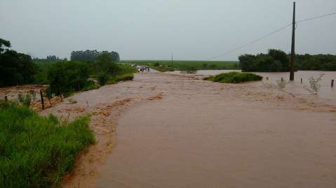 Chuva "sem fim" faz rio transbordar, interdita rodovia e erosão leva trator