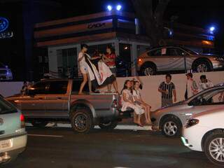 Em cima de veículo, torcedoras exibem bandeira do Corinthians.