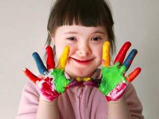 Criança com síndrome de Down brinca com tintas nas mãos. Notificar importa! (Foto: Divulgação/Movimento Down)