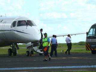 Ministro (de camisa branca, com celular na mão) ao desembarcar de avião da FAB em Campo Grande (Foto: André Bittar)