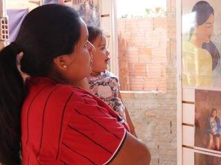 Terena da aldeia urbana Santa Mônica observa fotografias de uma das oficinas de um projeto voltado a inibir a violência contra mulheres indígenas (Foto: Kisie Ainoã)