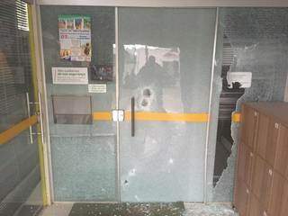 Porta de vidro da agência do Sicredi em Coronel Sapucaia arrebentada a tiros durante assalto (Foto: Direto das Ruas)