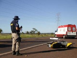 Policiais rodoviário federal colhendo informações sobre Biz Amarela ao lado de corpo e viatura do Samu (Foto: Fernando Antunes)