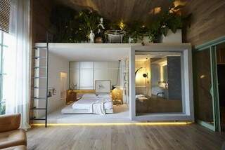 Na área de cerca de 40m² destinadas ao living e suíte, caixa branca recebe quarto e banheiro, com terraço verde.