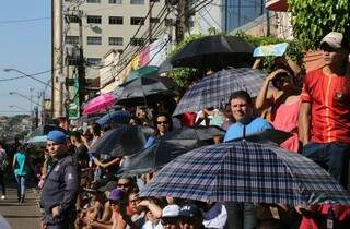 População veio preparada com sombrinhas para assistir desfile de aniversário de Campo Grande (Foto: Marcos Ermínio)