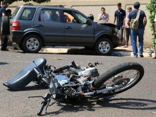 Moto ao solo e carro danificado após acidente durante fuga de suspeitos de assalto (Foto: Fernando Antunes)