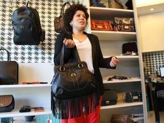 Erica mostra a bolsa de franjas, um ds sucessos da marca. (Foto: Marcos Ermínio)