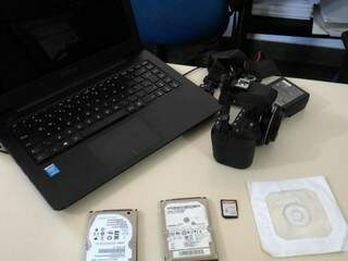 Computador, HDs, câmera, cartão de memória e cd com material pornográfico apreendidos (Foto: Kleber Clajus)
