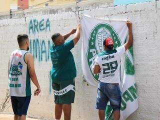 Torcedores fixam bandeiras verde e branca na sede da torcida organizada de Campo Grande. (Foto: Marina Pacheco).