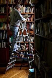 Ele sobe as escadas a procura de um livro que marcou história. 