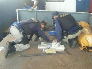 Policiais retiram droga de compartimento de caminhão. (Foto: Divulgação/ PRF)