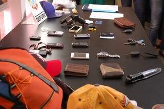 Celulares, carteiras, faca e um revólver foram apreendidos com os bandidos. (Foto: Viviane Oliveira)