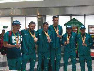 Paratletas medalhistas posam com a medalha de bronze no saguão do Aeroporto Internacional (Foto: Amanda Bogo)