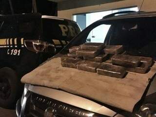 Os tabletes de cocaína estavam escondidos numa espécie de fundo falso embaixo do veículo. (Foto: PRF) 
