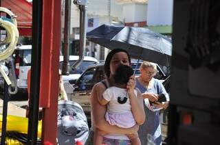 Nas ruas, mães usam sombrinha para proteger os filhos do sol (Foto: João Garrigó)
