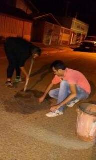 Josimar Omena e a esposa colocando concreto em buraco na Avenida Arthur Bernardes (Foto: Divulgação)