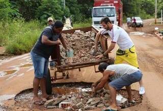 Moradores usam carroça para transportar restos de construção jogados em buraco da Via Parque (Foto: Eliel Oliveira)
