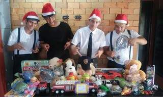 Em clima de Natal, funcionários mostram brinquedos arrecadados. (Foto: Divulgação)