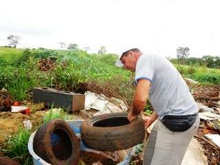 Agente de saúde recolhe pneus velhos durante mutirão contra a dengue no Jardim Piratininga (Foto: A. Frota)
