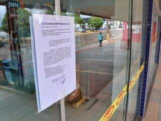Na porta de loja, decisão judicial que manda lacrar lojas. (Foto: Henrique Kawaminami)
