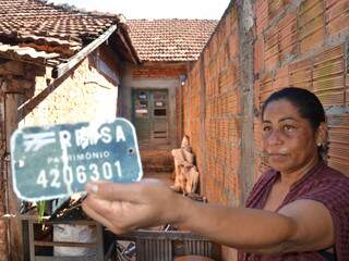Moradora mostra placa que identificada imóvel como patrimônio histórico da cidade. (Foto: Minamar Júnior)