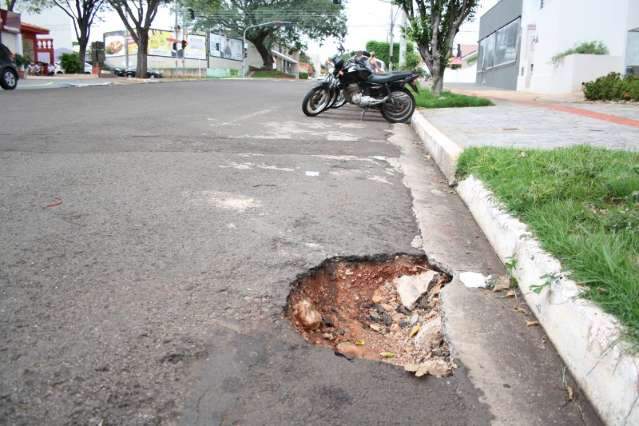 Asfalto cede e engole roda de carro na Rua da Paz