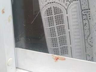 Marcas de sangue em janela que, segundo moradora, foram deixadas por invasor em tentativa de furto. (Foto: Direto das Ruas)