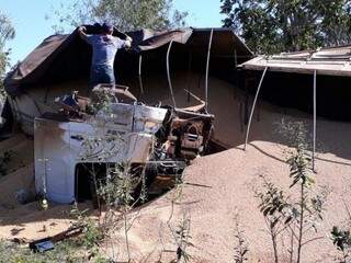 Carreta tombou e ficou virada para baixo com soja espalhada. (Foto: Porã News)