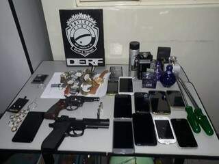 Simulacro de arma, celulares e outros produtos apreendidos com o trio (Foto: Divulgação/Derf)