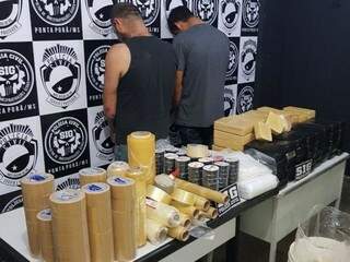Os dois homens presos com pasta-base e material usado para embalar droga (Foto: Porã News)