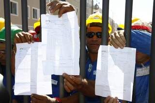 Trabalhadores mostram holerites e reclamam baixos salários (Foto: Cleber Gellio)