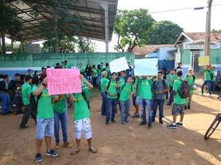 Alunos reunidos com cartazes em frente à escola (Foto: André Bittar)