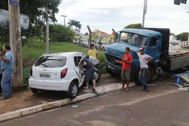 Caminh&atilde;o &ldquo;fura&rdquo; sinal, colide com Celta e motorista fica presa &agrave;s ferragens