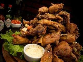 O nome ‘torre’ é explicado pela altura que o frango chega. A batata frita ‘forra’ o prato no Salomé Bar. 